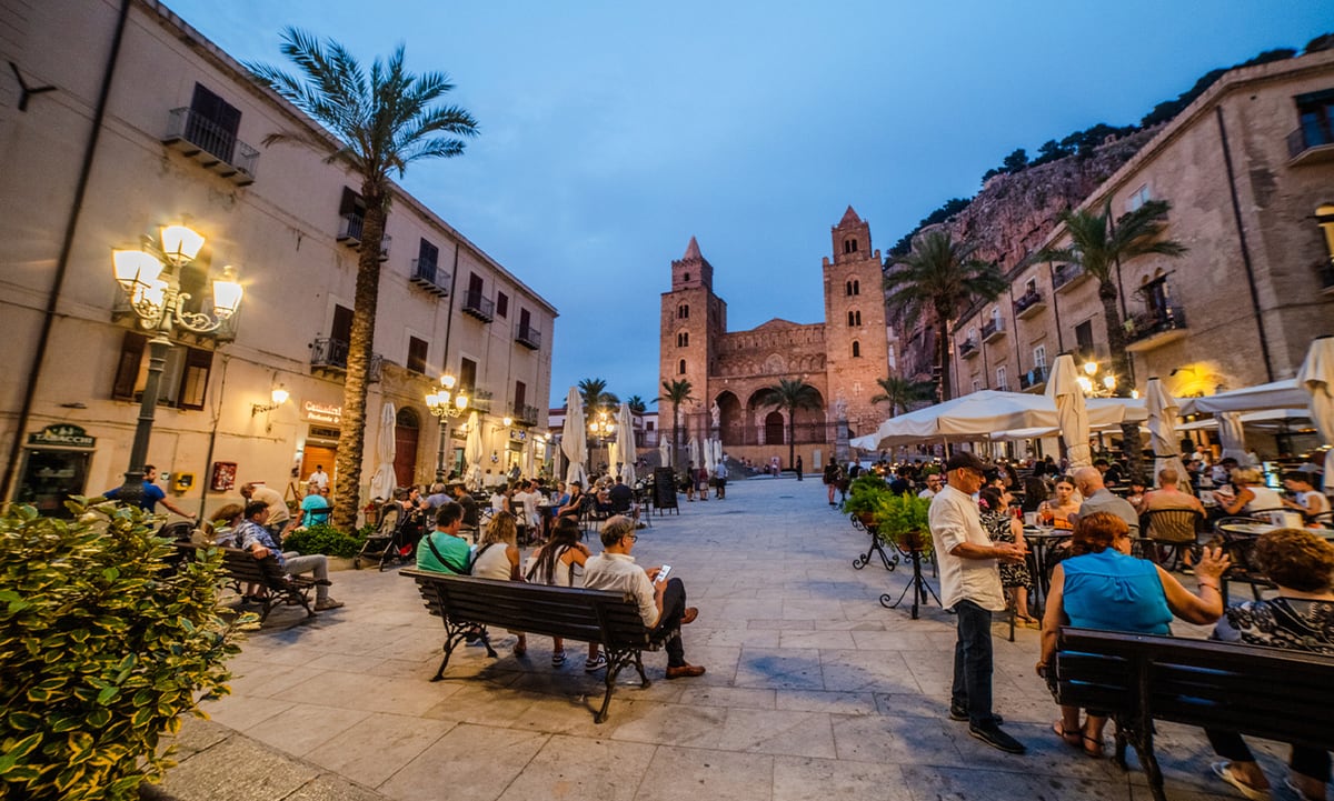 Piazza Duomo a Cefalù al crepuscolo, con la cattedrale e la Rocca sullo sfondo.